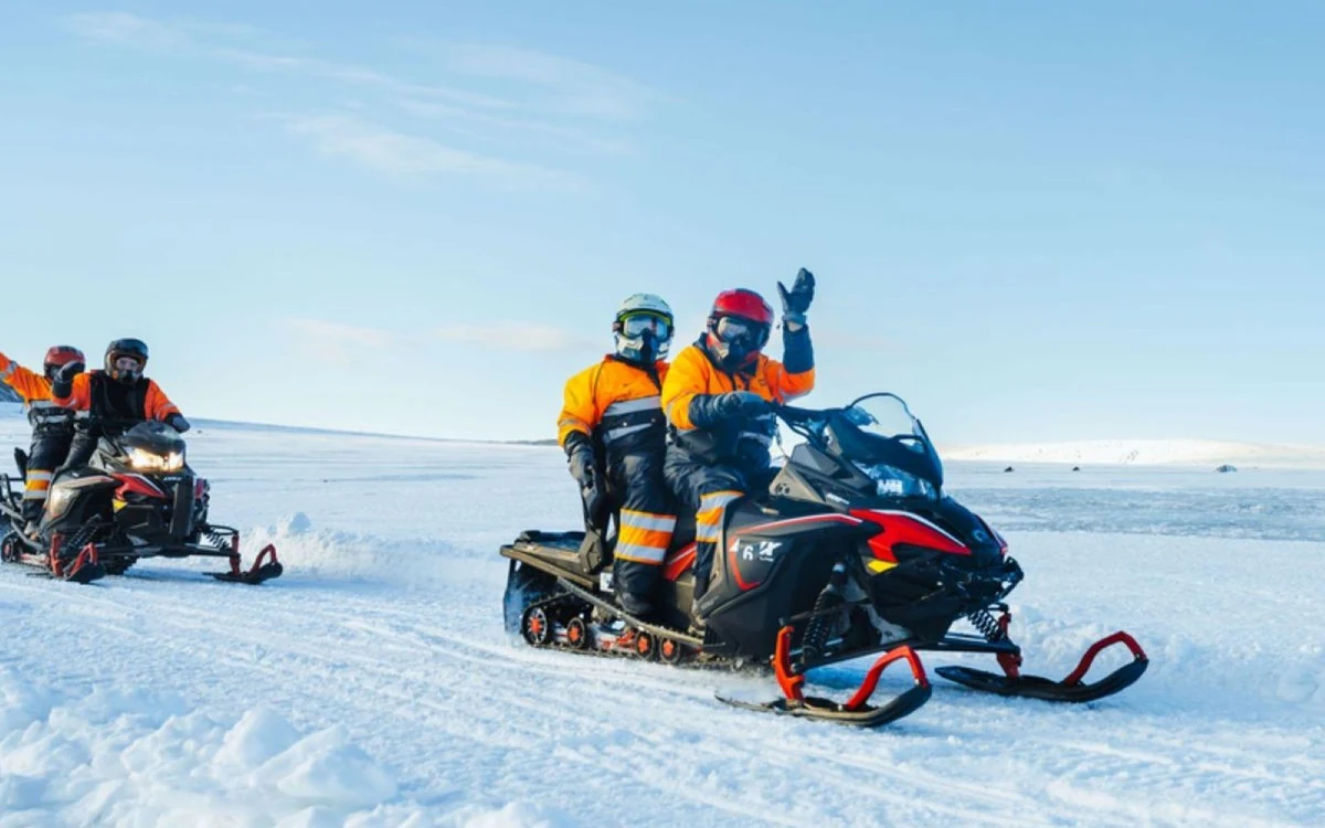 Eine Gruppe von Fahrzeugen und eine kleine Hütte auf der flachen weißen Oberfläche einer Eiskappe
