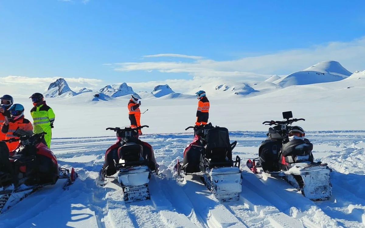 Motoslitte e una guida in un campo base su una calotta glaciale islandese